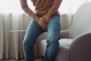 a person holding his hands to his crotch